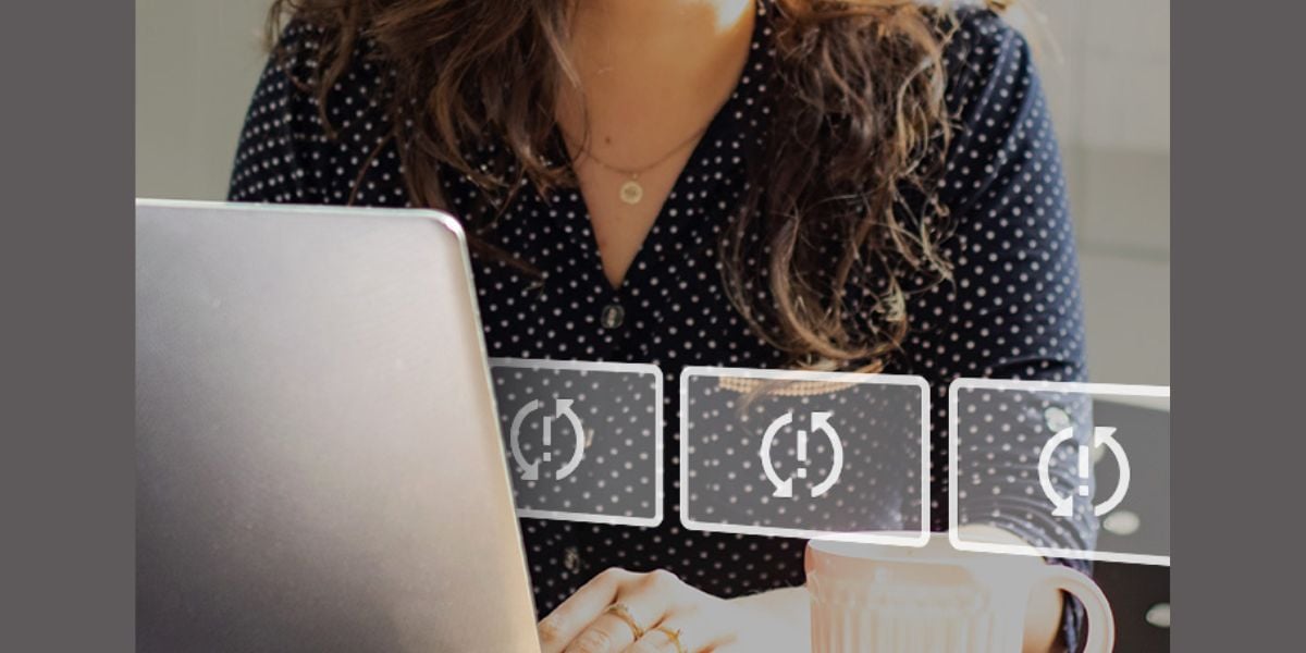 Software-Update am Laptop – Frau arbeitet mit Notebook, während ein Lade- oder Aktualisierungssymbol eingeblendet ist