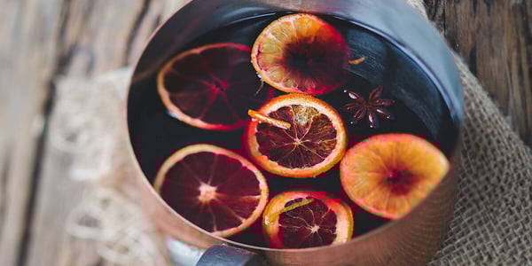 Glühwein mit Orangen in einem Metalltopf