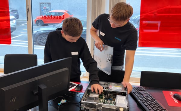 Zwei Jugendliche arbeiten gemeinsam an einem geöffneten Desktop-PC am Zukunftstag.
