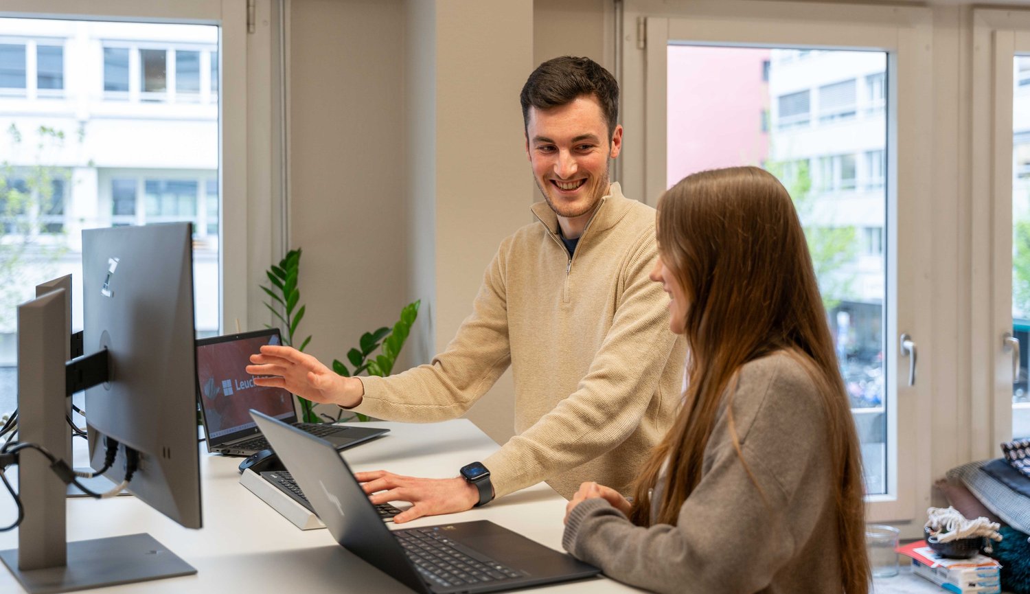 Bürogespräch am Stehpult zwischen zwei IT-Mitarbeitenden