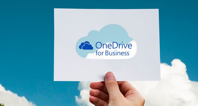 OneDrive for Business Cloudlösung – Hand hält Schild vor blauem Himmel mit Microsoft Cloud-Symbol