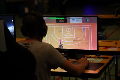 Eine Person die am Computer Videogame spielt.