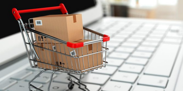 Einkaufswagen mit Schachteln auf einer Notbook-Tastatur