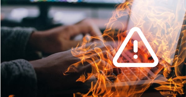 Hände tippen auf einer Tastatur, davor eine Flammenanimation mit einem Warnsymbol 