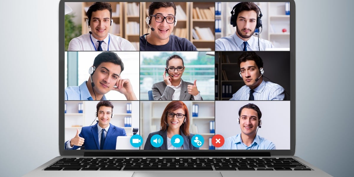 Laptopbildschirm zeigt eine Teams Videokonferenz zwischen lächelnden Teilnehmern mit Headsets.